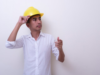 engineer with hands crossed wearing yellow helmet on white background