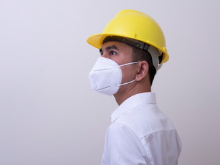 Fototapeta na wymiar Asian industrial workers wear yellow hard hats, wear protective masks for their health