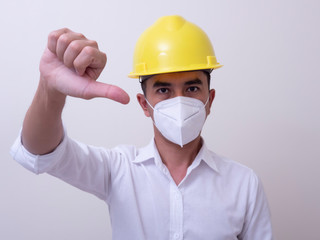 Fototapeta na wymiar Asian industrial workers wear yellow hard hats, wear protective masks for their health