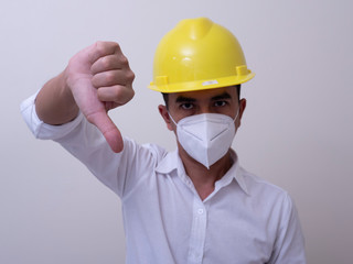 Asian industrial workers wear yellow hard hats, wear protective masks for their health