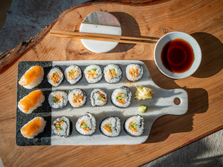 Set of sushi on a chopping board with chopsticks and soy sauce
