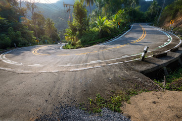 stunning view of empty winding road like a snake in jungle between Coconut palms at sunrise in tropical island Ko Pha Ngan to Haad Sadet Beach