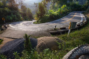 Fototapeta na wymiar stunning view of empty winding road like a snake in jungle between Coconut palms at sunrise in tropical island Ko Pha Ngan to Haad Sadet Beach