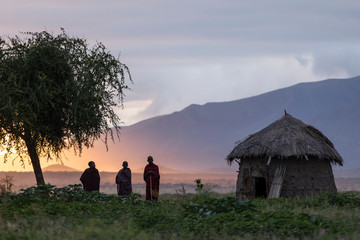 Arusha, Tanzania on 1st June 2019. Group of masai people at there village during the sunrise with beautiful colourful background - obrazy, fototapety, plakaty