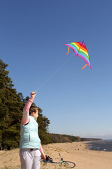 girl with a flying kite on the beach