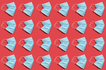 COVID-19 pattern of surgical face masks on red background. Protection against coronavirus. Healthcare and medical concept