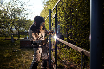 Naklejka premium welder welds metal in nature with sparks