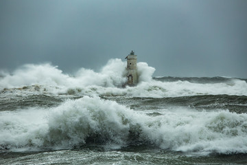 The lighthouse of the Mangiabarche shrouded by the waves of a mistral wind storm