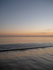 Sunset on small waves seaside beach