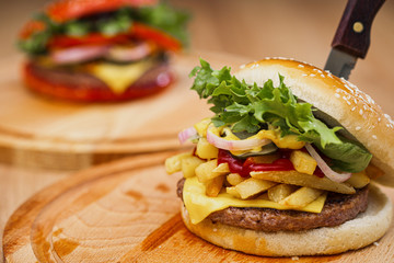 A set of different burgers. Fast food restaurant board. A diverse snack menu. Serving on a wooden board on a black background.
