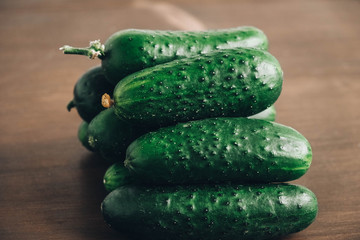 Fresh green cucumbers on a wooden table background. Copy, empty space for text