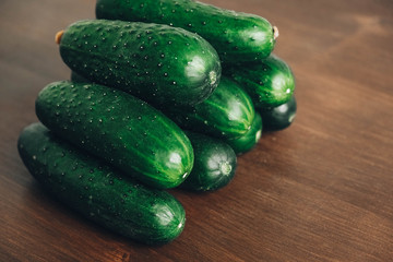 Fresh green cucumbers on a wooden table background. Copy, empty space for text