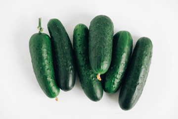 Fresh green cucumbers on white background. Top view. Copy, empty space for text