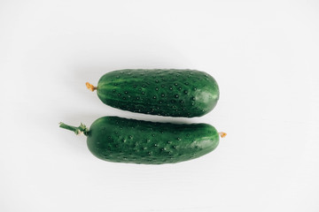Fresh green cucumbers on white background. Top view. Copy, empty space for text