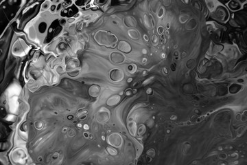 
Abstract black and white background of mixed colors. The spread of paint on the surface. Colorful wallpaper for design