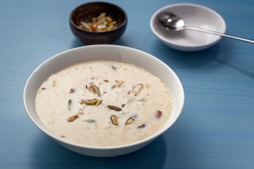Kheer or Payasam is a type of rice pudding from the Indian subcontinent, made by boiling milk and sugar and is flavoured with dry fruits and nuts, served in ceramic bowl.