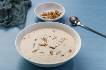 Kheer or Payasam is a type of rice pudding from the Indian subcontinent, made by boiling milk and sugar and is flavoured with dry fruits and nuts, served in ceramic bowl.
