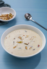 Kheer or Payasam is a type of rice pudding from the Indian subcontinent, made by boiling milk and sugar and is flavoured with dry fruits and nuts, served in ceramic bowl.