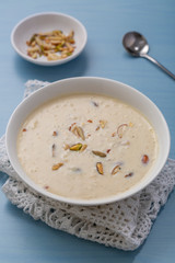 Kheer or Payasam is a type of rice pudding from the Indian subcontinent, made by boiling milk and sugar and is flavoured with dry fruits and nuts, served in ceramic bowl.