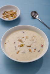 Kheer or Payasam is a type of rice pudding from the Indian subcontinent, made by boiling milk and sugar and is flavoured with dry fruits and nuts, served in ceramic bowl.