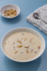 Kheer or Payasam is a type of rice pudding from the Indian subcontinent, made by boiling milk and sugar and is flavoured with dry fruits and nuts, served in ceramic bowl.