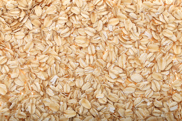 Oat flakes, uncooked oats in bowl with poon and wheat ears on white background. Concept of healthy eating, vegan food, healthy food, breakfast.