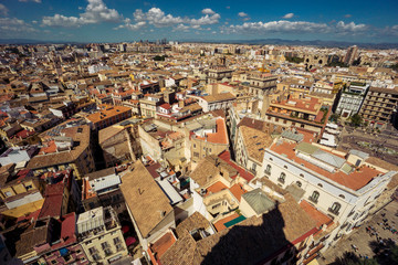Fototapeta na wymiar Scenic view from the height of the cathedral in the center of Valencia. Many tile roofs on a background of bright clouds. Typical landscape of Spain