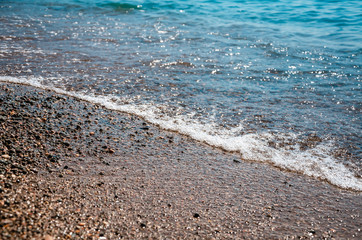 Seascape background colorful stone beach with sea wave