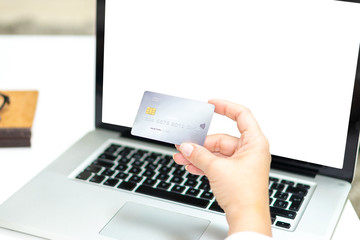 Woman hand with credit card and blank laptop screen