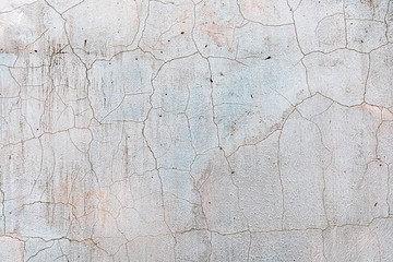Cracked plaster on the wall. Concrete background. Abstraction from a cracked plaster in construction.