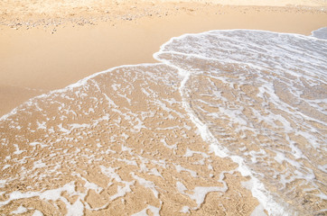 Seascape background white sea waves on golden sandy beach