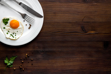 Fried eggs on plate - dark wooden desk top view space for text