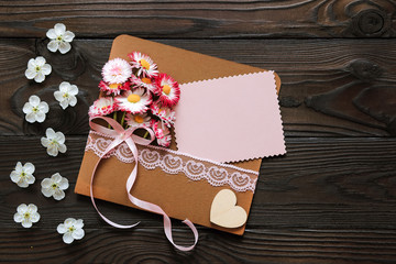 envelope with pink flowers and a greeting card for the holiday on a dark wooden background
