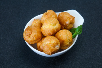 Sweet tasty profiteroles heap in the bowl