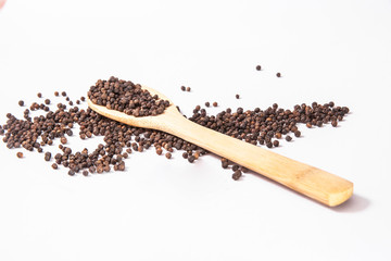 natural organic black pepper in wooden spoon