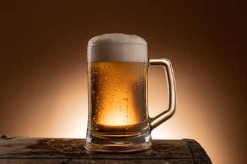 Pint glass of Ale, beer, lager sat on a wooden bench in a pub beer garden