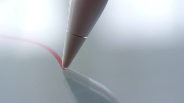 Macro Follow Shot of an artist hand drawing on a digital tablet with pencil. Pencil is Connected to the Camera. Gripped Shot.