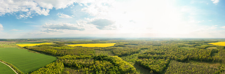 Fototapeta na wymiar Scenic landscape of countryside from bird's eye view, springtime. Aerial drone view of woodland and farmland