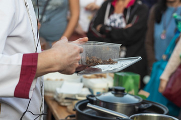 Preparing crickets in a pan for eating