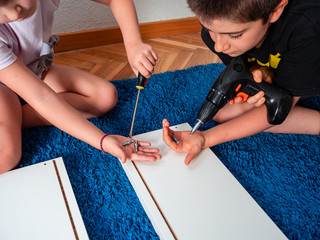 SOME BROTHERS SHOW THE SCREWS OF A NEW PIECE OF FURNITURE