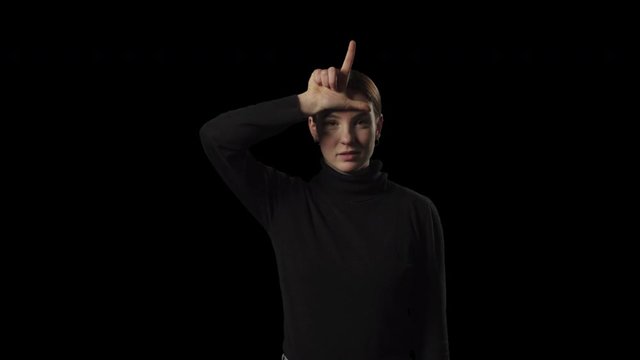Young woman showing the loser hand sign on forehead. Transparent isolated alpha channel background.
