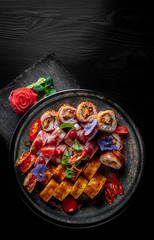 set of sushi roll with salmon, avocado, cream cheese, cucumber, rice, caviar, eel, tuna in plate on black wooden table background