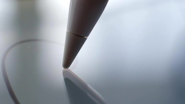 Macro Follow Shot of an artist hand drawing on a digital tablet with pencil. Pencil is Connected to the Camera. Gripped Shot.