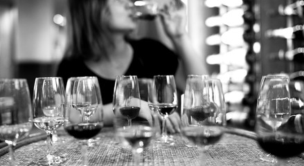 glass of champagne, portwein and red wine on the 
 wooden table, a young woman is drinking alcohol...