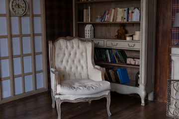 interior of the room. classic beige leather chair next to a bookcase