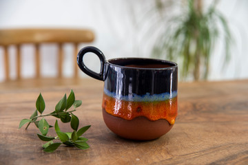 colorful handmade ceramic coffee cup on wooden table 