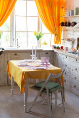 kitchen interior with yellow curtains and yellow tablecloth on the table
