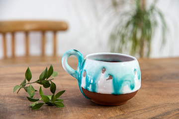 colorful handmade ceramic coffee cup on wooden table 