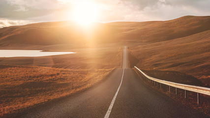 a long straight road on iceland with sunset