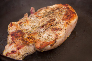 Roasted steak on the frying pan in the kitchen